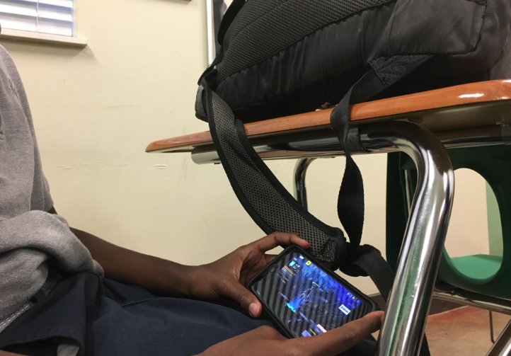 Some students are so addicted to games that they hide their phones behind their bags during class to play.