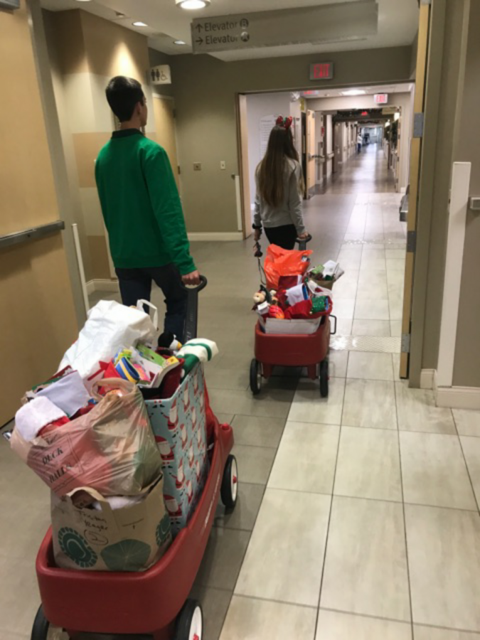 (Left to right) Braden Strackman and Amanda Brennan pulling wagons of stockings to drop off.