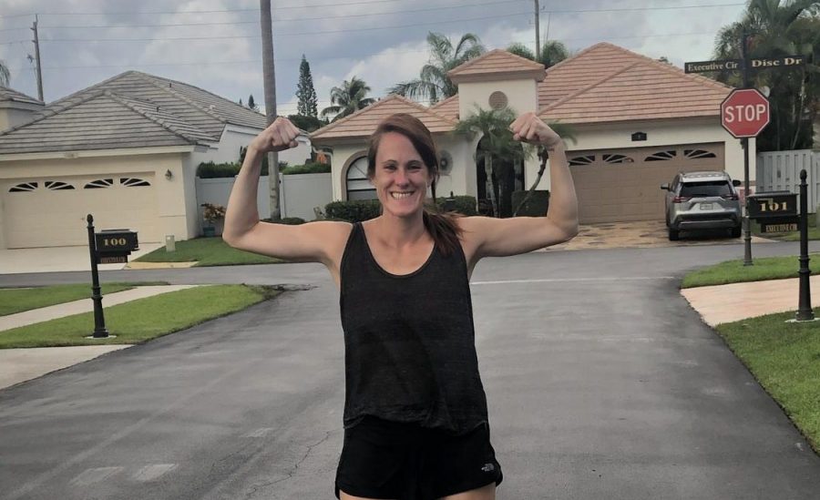 Mrs. Taylor, the cross country coach, flexes after running her 500th mile during quarantine.