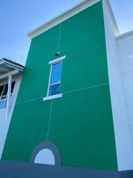 The newly painted exterior walls shine bright as an emerald. 